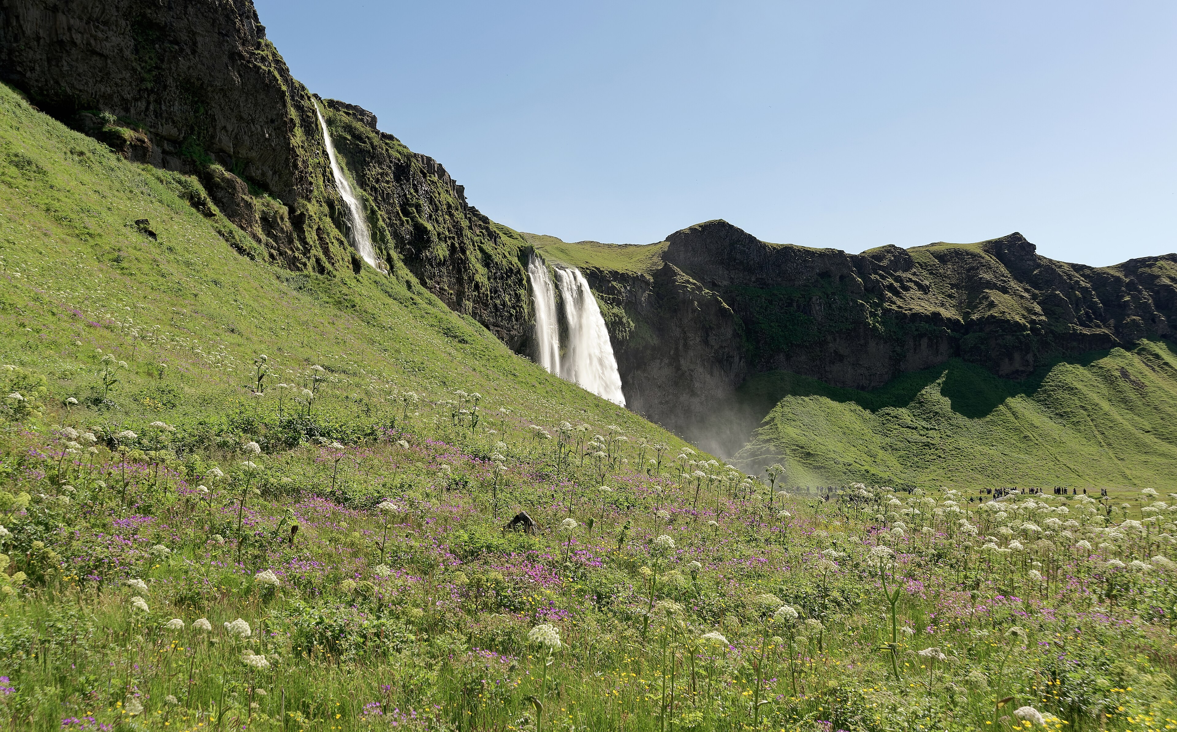 Seljalandsfoss falling from a cliff on the south coast, with a path behind the curtain